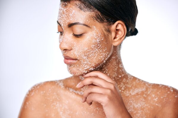 woman using face scrub to exfoliate